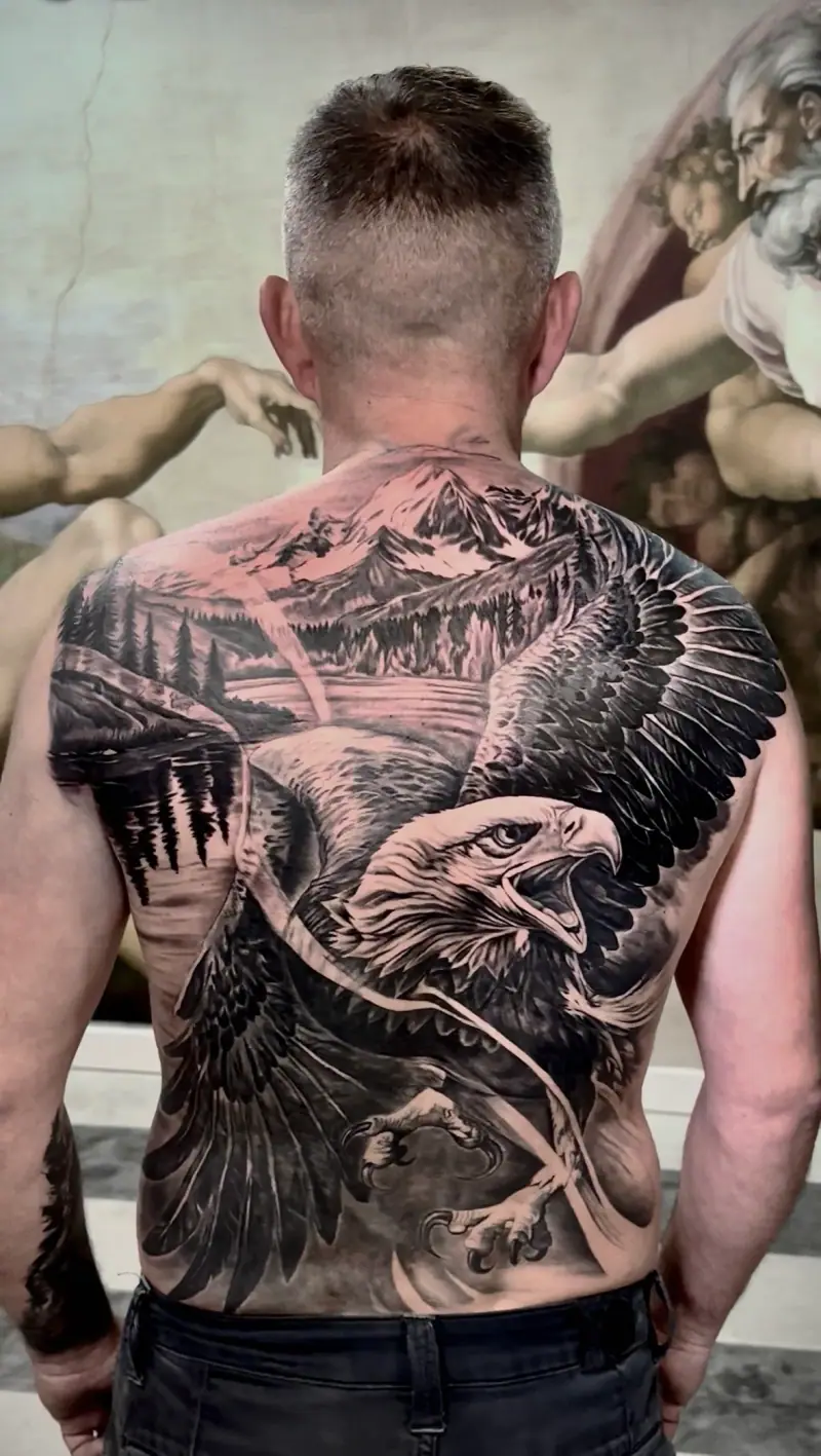 Cover up de espalda completa con águila y paisaje de montañas