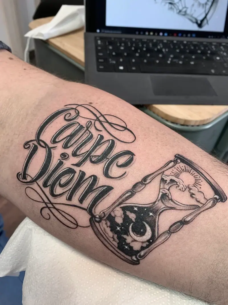 Tatuaje de lettering «Carpe Diem» con reloj de arena
