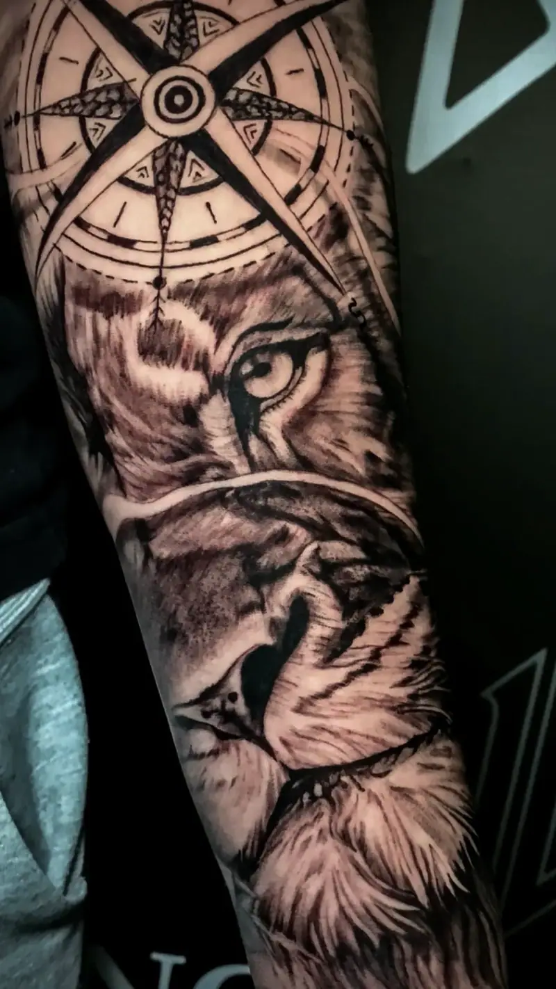 Tatuaje realista de un león fusionado con una rosa de los vientos